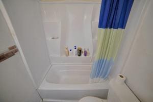 bathroom featuring shower / tub combo with curtain and toilet