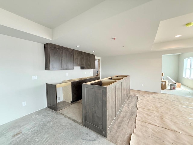 L146 Winn Dr, Waunakee, WI 53597 - kitchen featuring dark brown cabinetry, open floor plan, a center island with sink, recessed lighting, and a raised ceiling