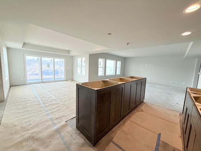 L146 Winn Dr, Waunakee, WI 53597 - kitchen featuring dark brown cabinets, a raised ceiling, recessed lighting, open floor plan, and visible vents