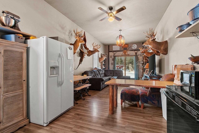 kitchen featuring white refrigerator with ice dispenser, hardwood / wood-style flooring, range with electric stovetop, and ceiling fan