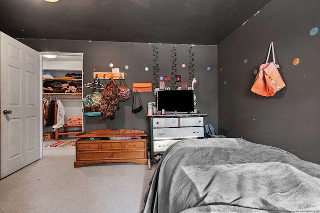 bedroom featuring a closet, a walk in closet, and carpet flooring