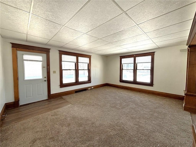 interior space featuring plenty of natural light, a paneled ceiling, and carpet floors