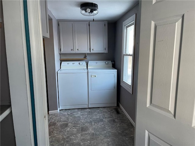 laundry area with separate washer and dryer and cabinets