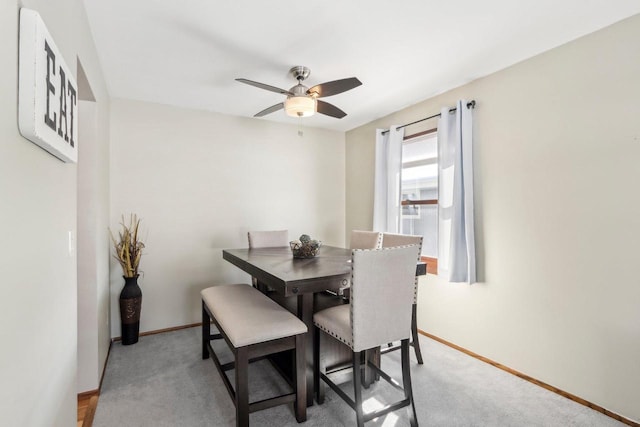 carpeted dining room featuring ceiling fan