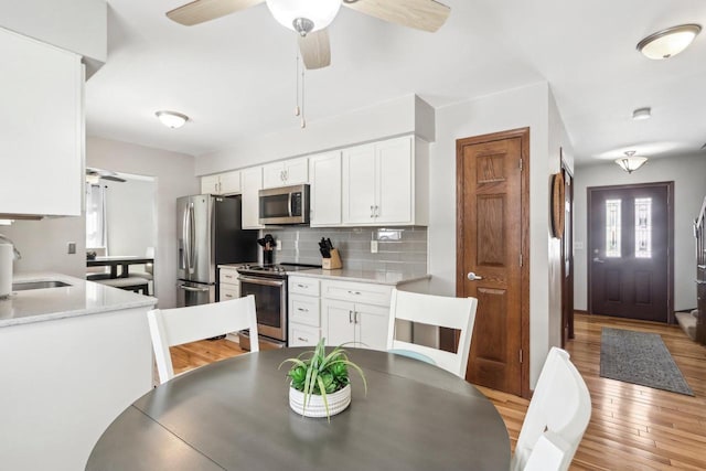 kitchen featuring white cabinetry, backsplash, sink, and stainless steel appliances