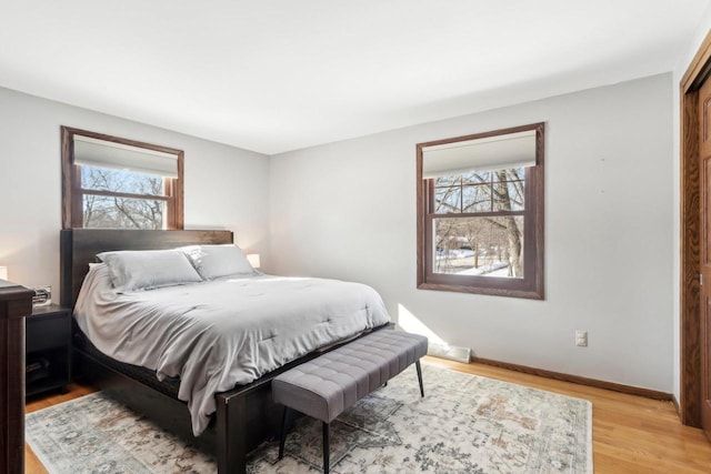 bedroom with multiple windows and light hardwood / wood-style floors