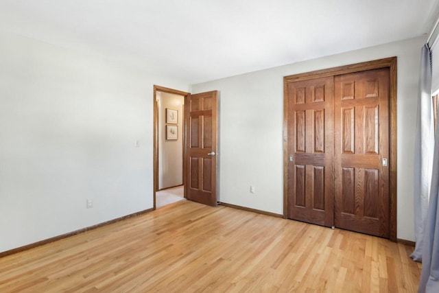 unfurnished bedroom with light wood-type flooring and a closet