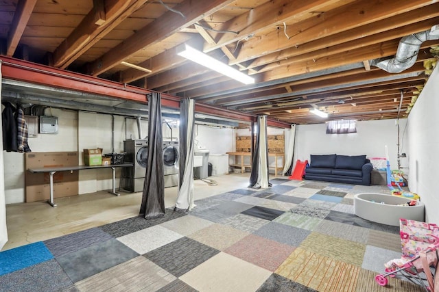 basement with electric panel, sink, and separate washer and dryer