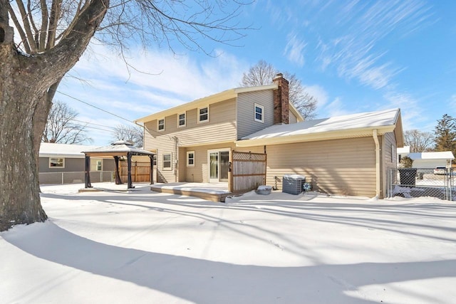 snow covered back of property featuring a gazebo