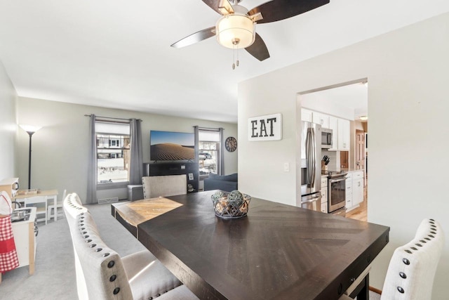 carpeted dining space featuring ceiling fan