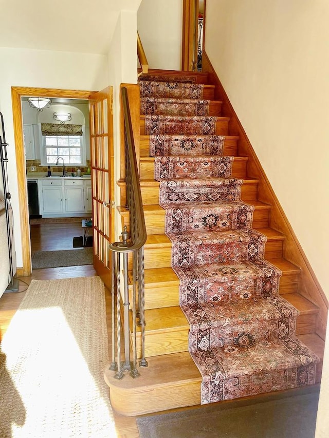 staircase with sink and wood-type flooring