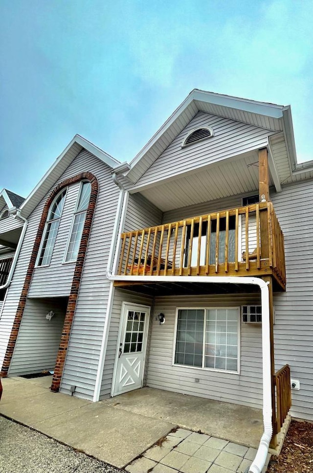 rear view of property featuring a patio area and a balcony