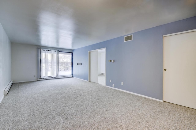 carpeted spare room featuring a baseboard radiator