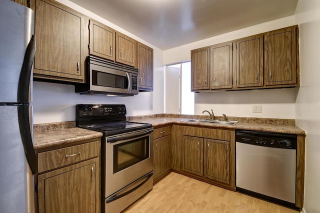 kitchen featuring sink, stainless steel appliances, and light hardwood / wood-style floors