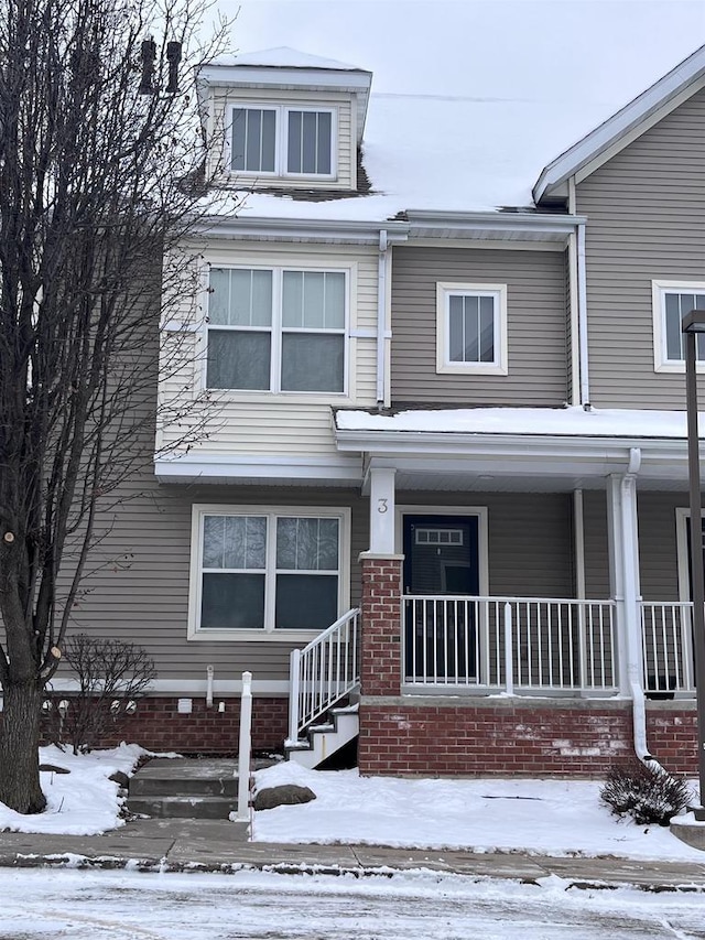 townhome / multi-family property featuring covered porch