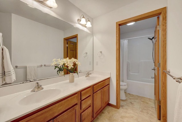 bathroom featuring tile patterned flooring, a sink, toilet, and double vanity