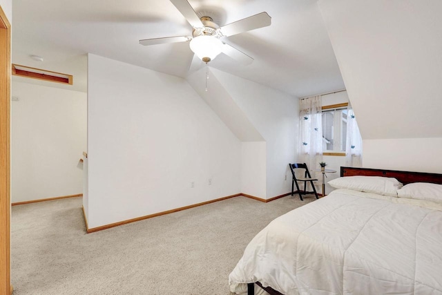 bedroom with light carpet, baseboards, vaulted ceiling, and a ceiling fan