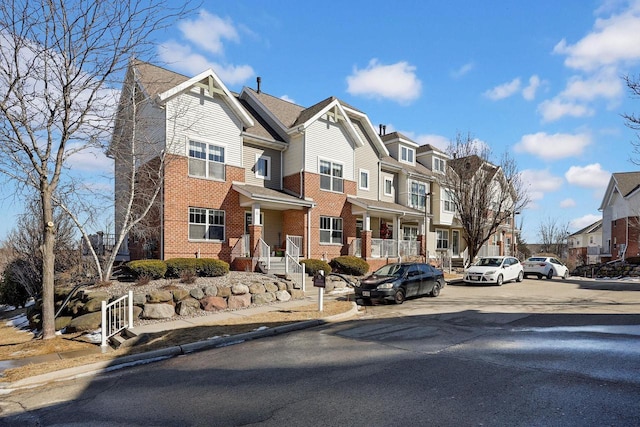 view of front of home featuring brick siding and a residential view