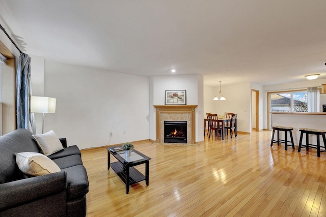 living area featuring baseboards, a fireplace, and light wood-style floors