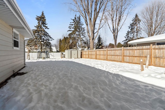 yard covered in snow featuring a storage unit