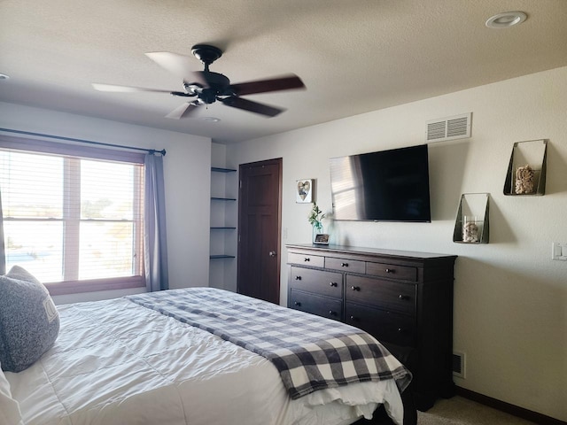 bedroom featuring ceiling fan and a textured ceiling