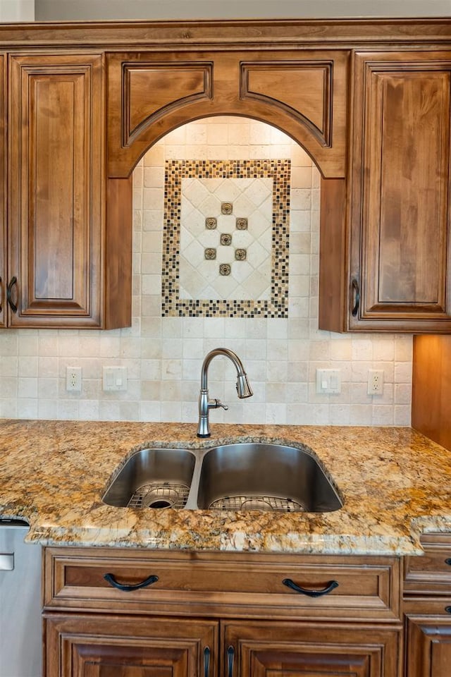 kitchen with sink, backsplash, and light stone countertops