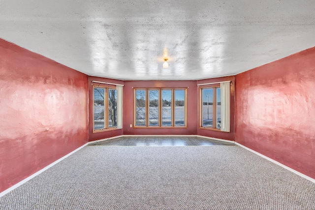 carpeted empty room with a textured ceiling