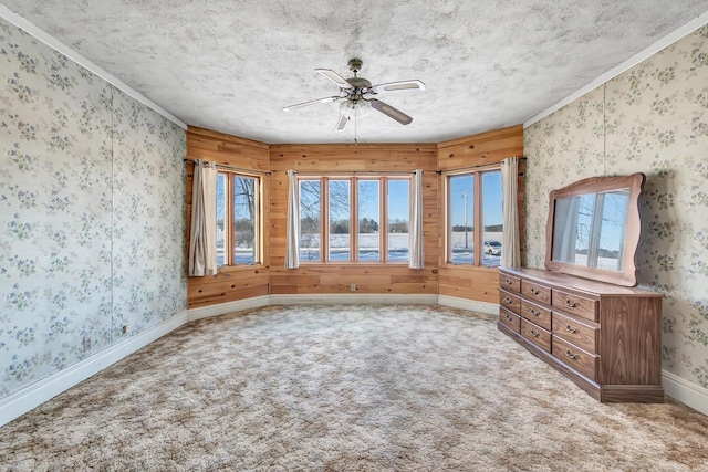 spare room with ceiling fan, carpet floors, a textured ceiling, and ornamental molding