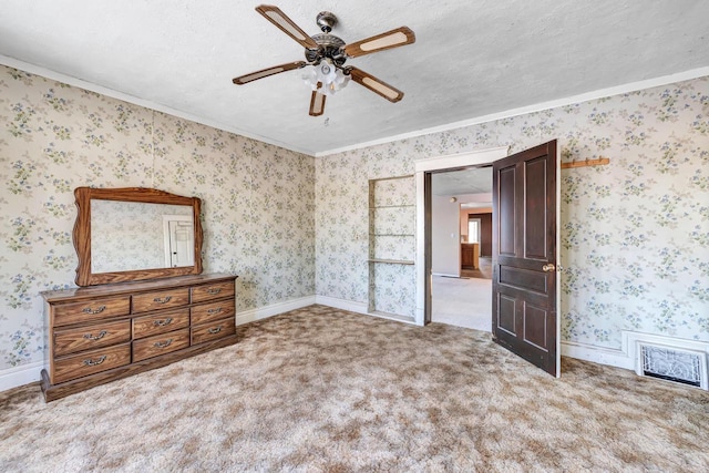 unfurnished bedroom with a textured ceiling, ornamental molding, light colored carpet, and ceiling fan