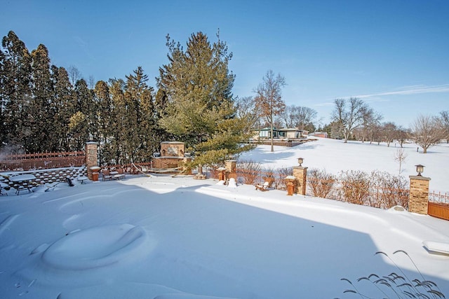 snowy yard with an outdoor fireplace