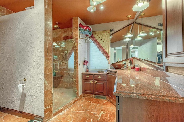 bathroom featuring a shower with door and vanity