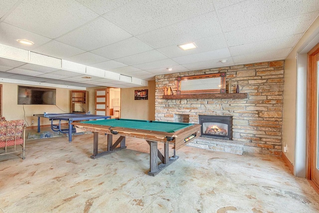 rec room featuring a fireplace, a drop ceiling, billiards, and concrete flooring