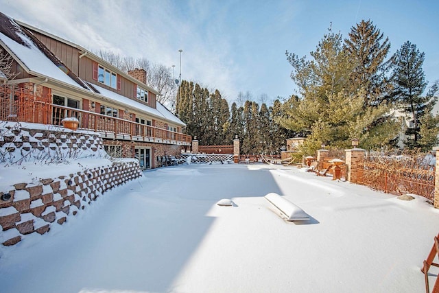 yard covered in snow with a deck