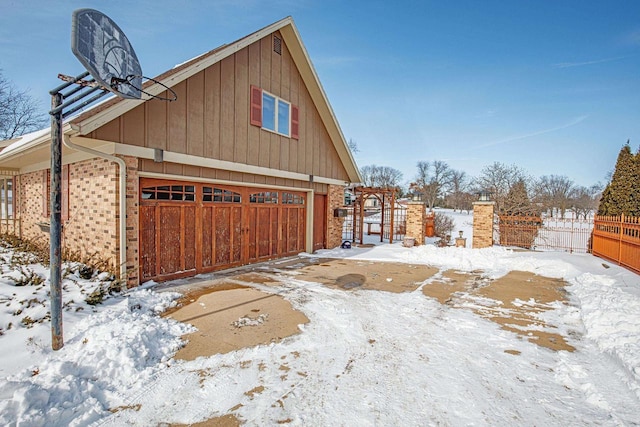 snow covered property with a garage