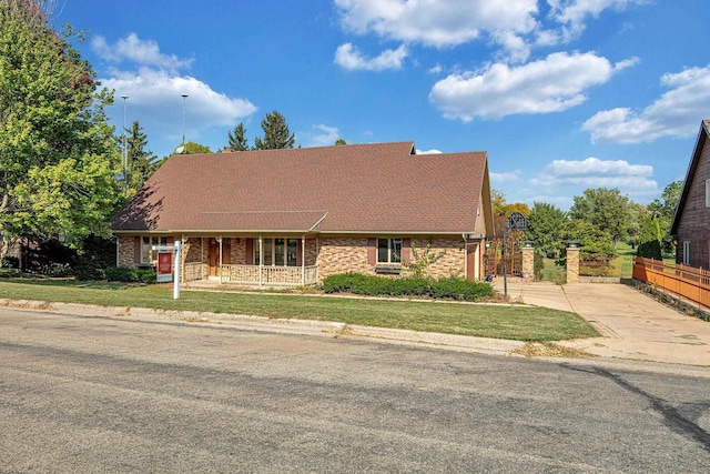 view of front of house featuring covered porch and a front lawn