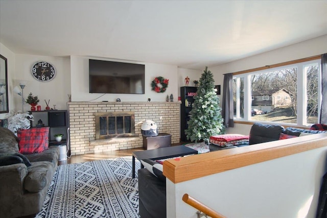 living room featuring a brick fireplace and hardwood / wood-style floors