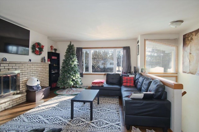 living room featuring a brick fireplace and wood-type flooring