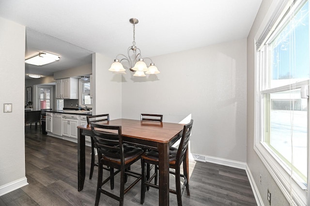 dining area featuring a chandelier, sink, and dark hardwood / wood-style floors