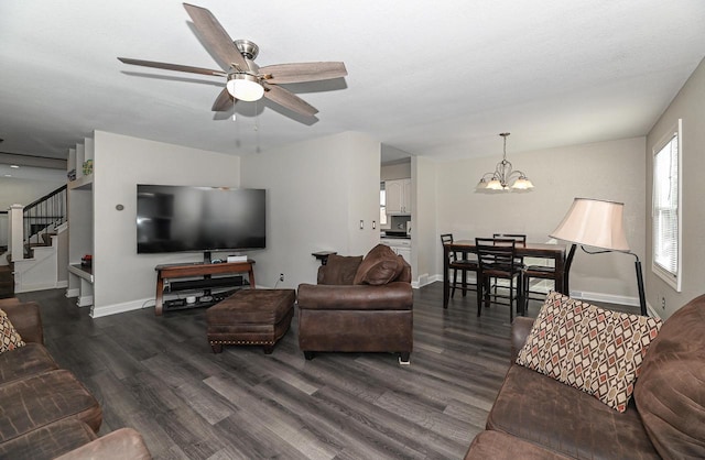 living room with dark hardwood / wood-style flooring and ceiling fan with notable chandelier