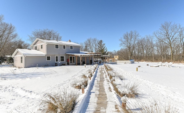 view of snow covered rear of property