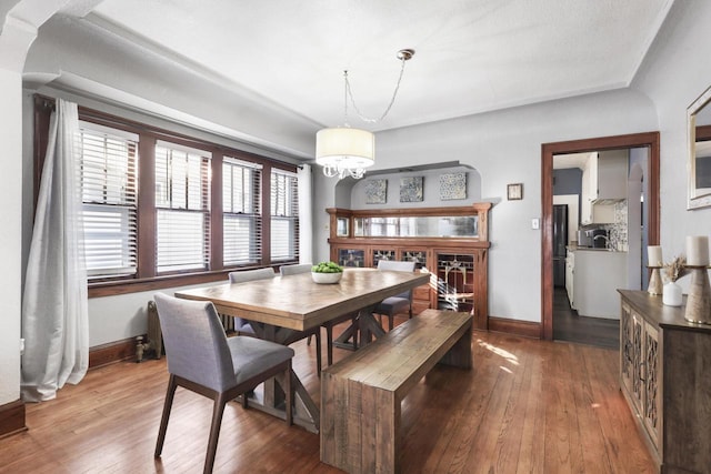 dining area with hardwood / wood-style flooring and a notable chandelier