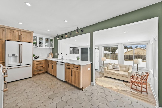 kitchen featuring kitchen peninsula, sink, and white appliances