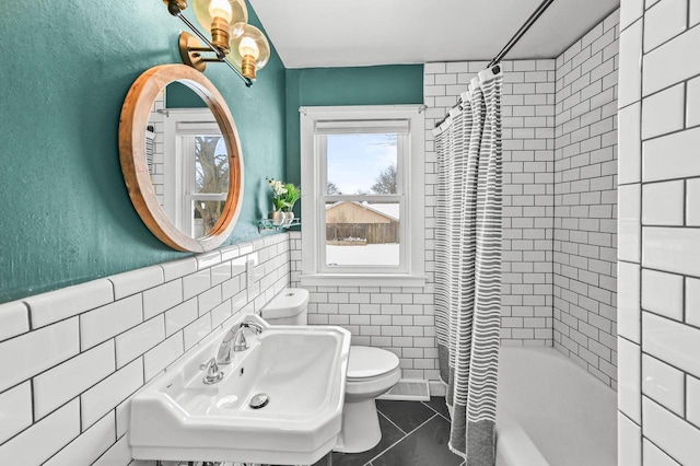 full bathroom featuring tile walls, tile patterned floors, toilet, shower / tub combo, and sink