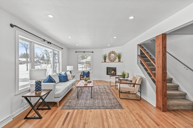 living room with a baseboard heating unit and light hardwood / wood-style floors