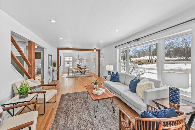 living room featuring light wood-type flooring and a notable chandelier