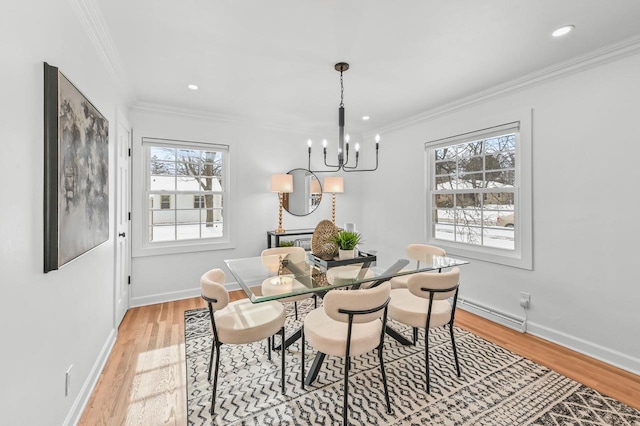 dining room featuring light hardwood / wood-style flooring, crown molding, plenty of natural light, and a chandelier