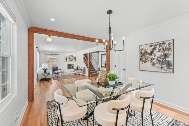 dining space with a chandelier, light hardwood / wood-style floors, and crown molding