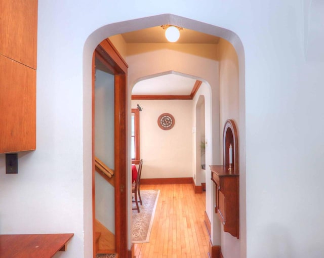 hall featuring light wood-type flooring and crown molding