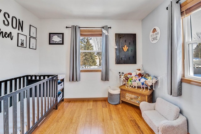 bedroom with hardwood / wood-style flooring and a crib