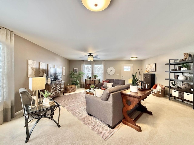 carpeted living room with ceiling fan